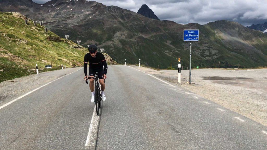 Cyclist reaching the summit of Passo del Bernina