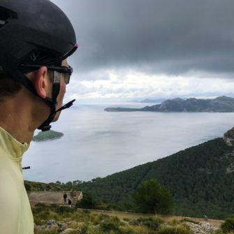 Cyclist admiring the view from pepperpot on the Cap de Formentor cycle route