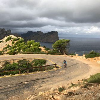cyclist on the cap de formentor cycling route, Mallorca, approaching the lighthouse