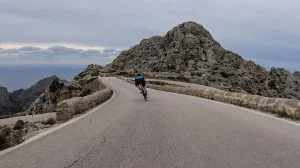 Cyclist cycling Sa Calobra descent towards spiral road from Coll dels Reis