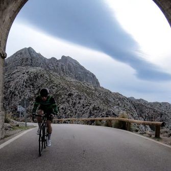Cyclist coming through arch on Mallorca's iconic Sa Calobra climb