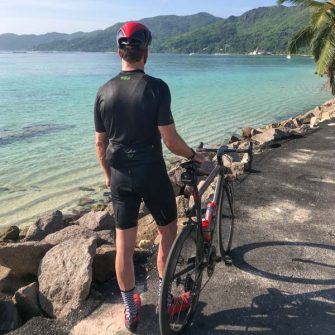 Cyclist and bike at Anse Royale beach Mahé island Seychelles