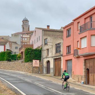 Cyclist cycling through small town of Ulldemolins, Costa Daurada, Spain