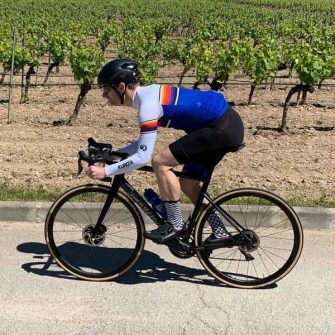 Cyclist in front of vines