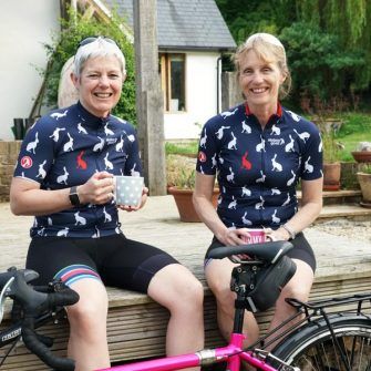 Two women wearing stolen goat cycling jerseys