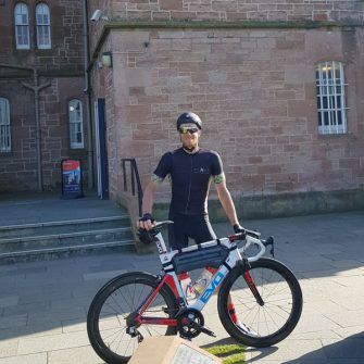 Cyclist at Inverness castle after completing the NC500 cycle route