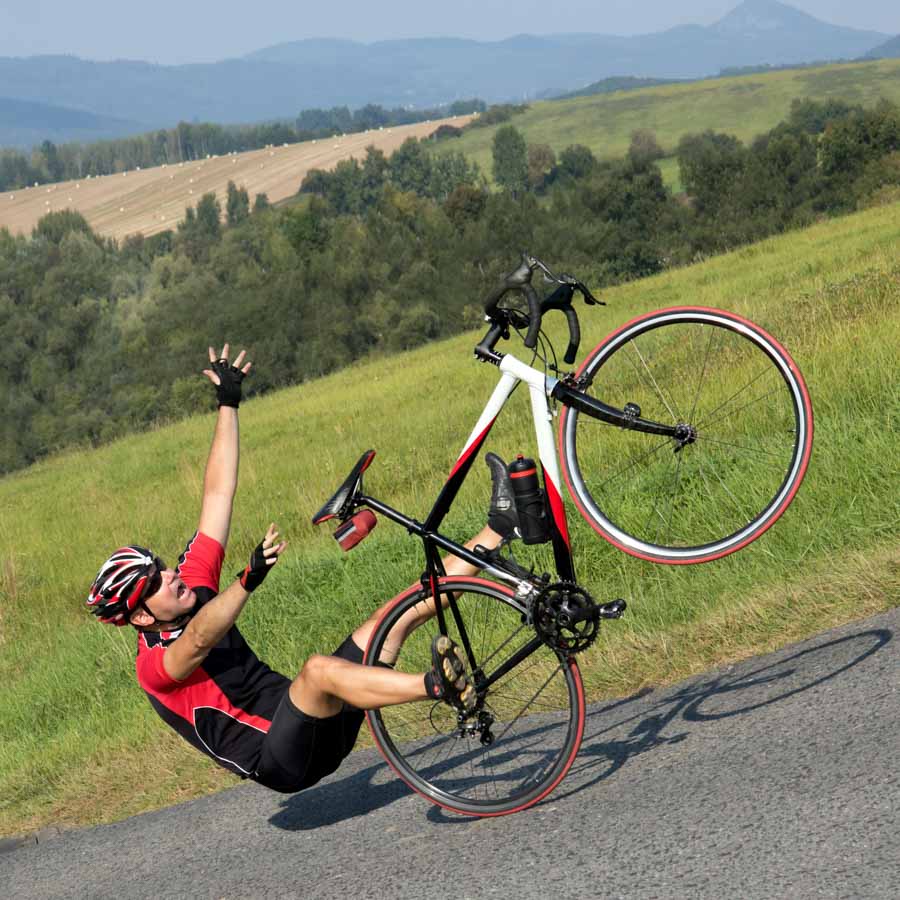 cyclist falling off bike showing the importance of cycle travel insurance