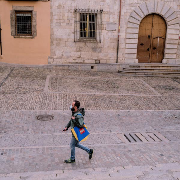 Man walking across empty square in Girona