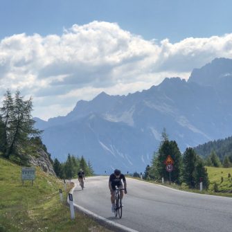 Cyclists approaching the summit of Falzarego Pass, Dolomites, Italy