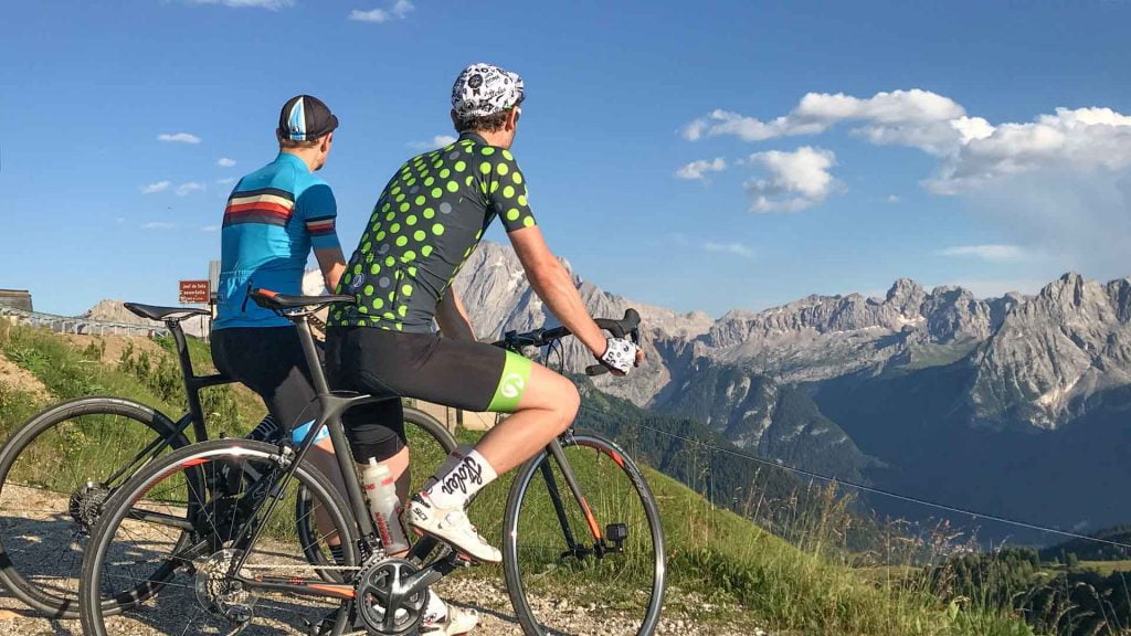Cyclists admiring view from top of Passo Sella, Italian Dolomites