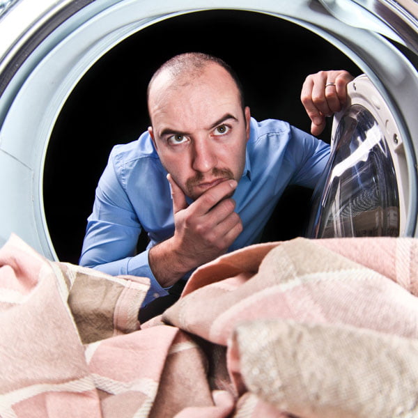 Man looking into a tumble dryer
