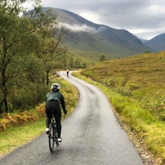 Cyclist riding up a hill in scotland