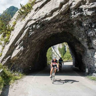 Cyclist through a rock tunnel on a cycling route in Switzerland