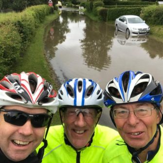 Cyclists in front of flooded road 