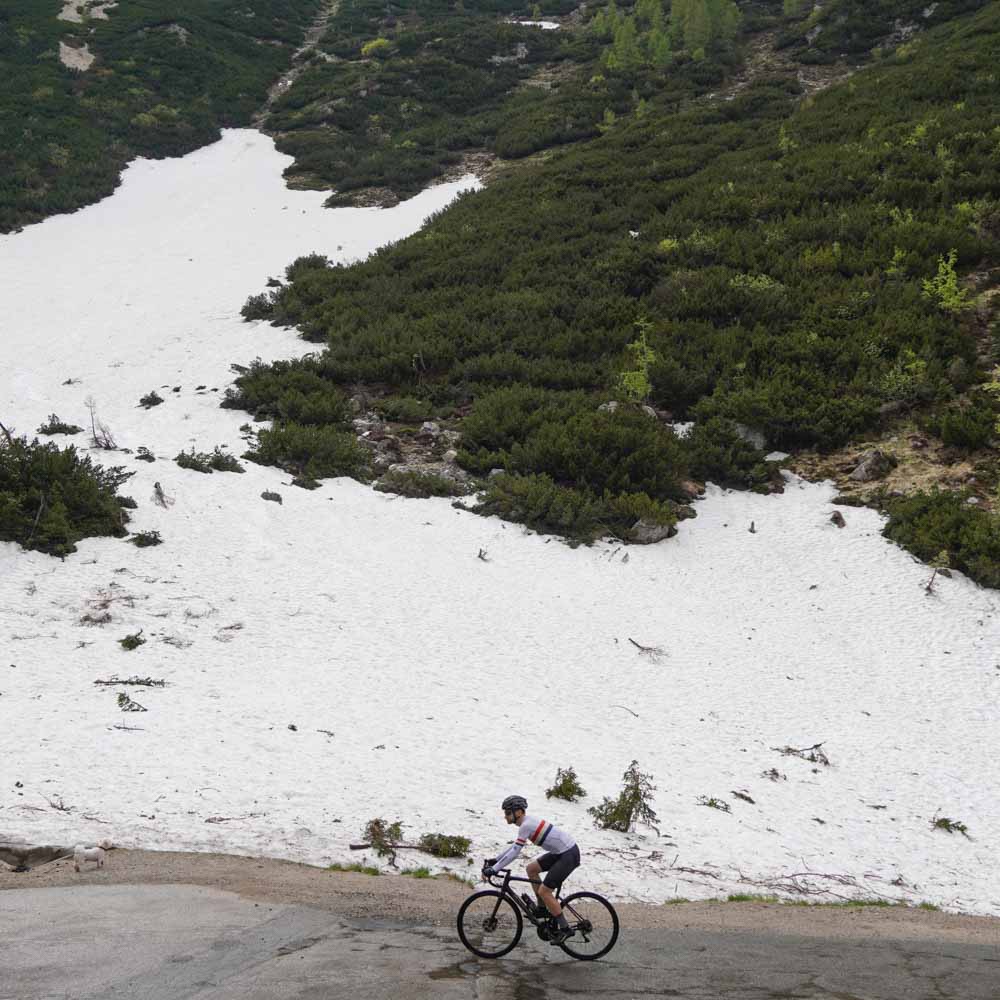 Cyclist surrounded by snow on the Vrisc Pass in Slovenia