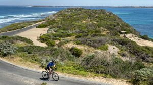 Cyclist cycling on sandy promentary in Victoria, Australia