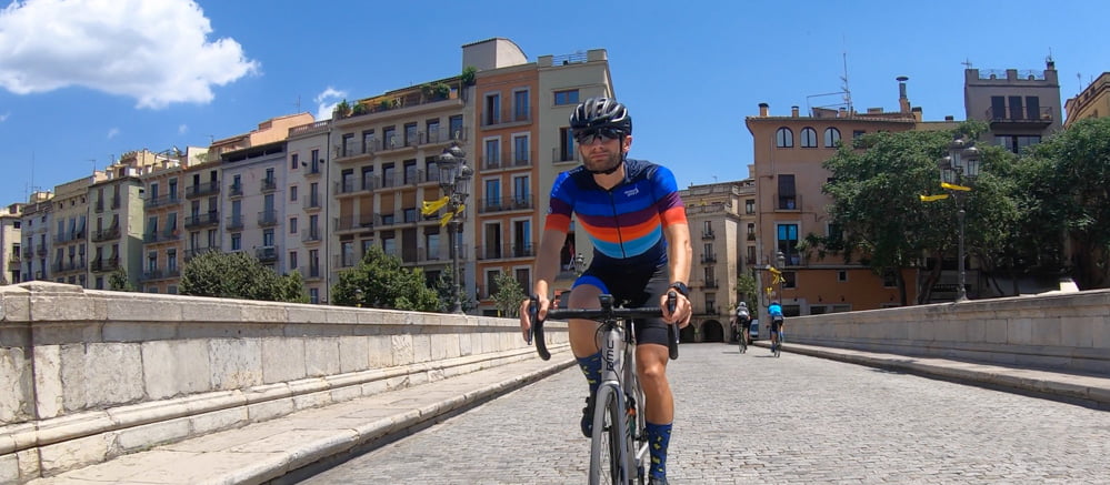 Bike tours in Girona with cyclist on a bridge