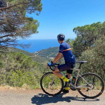 Cyclist looking down towards the coast near Sant grau