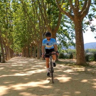 Cyclist cycling around the edge of Lake Banyoles, Girona