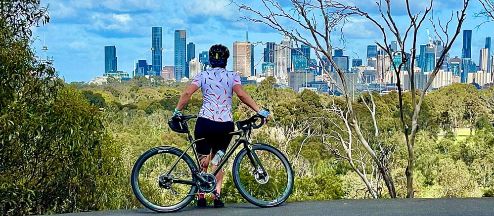 Cyclist in Melbourne admiring the city skyline