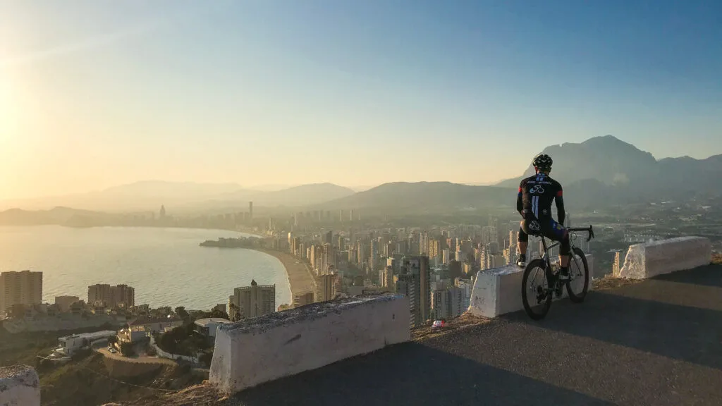 A road cyclist admiring the view over Benidorm as the sun sets