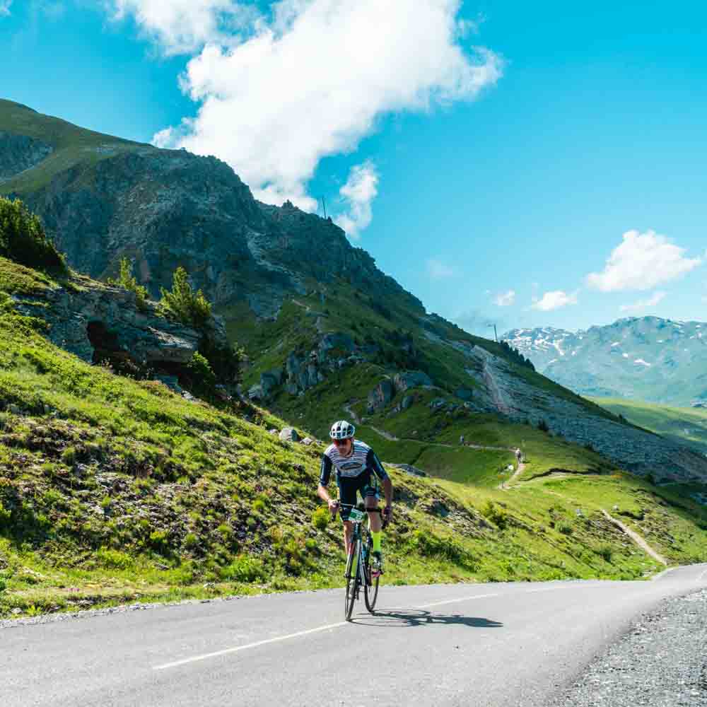 A cyclist cycling in the alps mountain sloping road