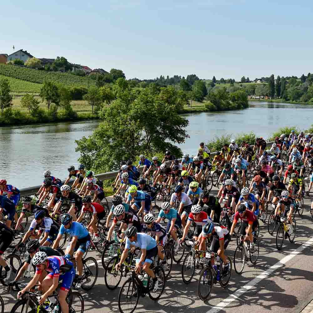 Many cyclists are cycling on the river bank roads gran fondo Luxembourg