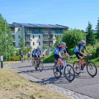 Some cyclists are cycling through the streets of the German Alps Hotel Am Kurhaus