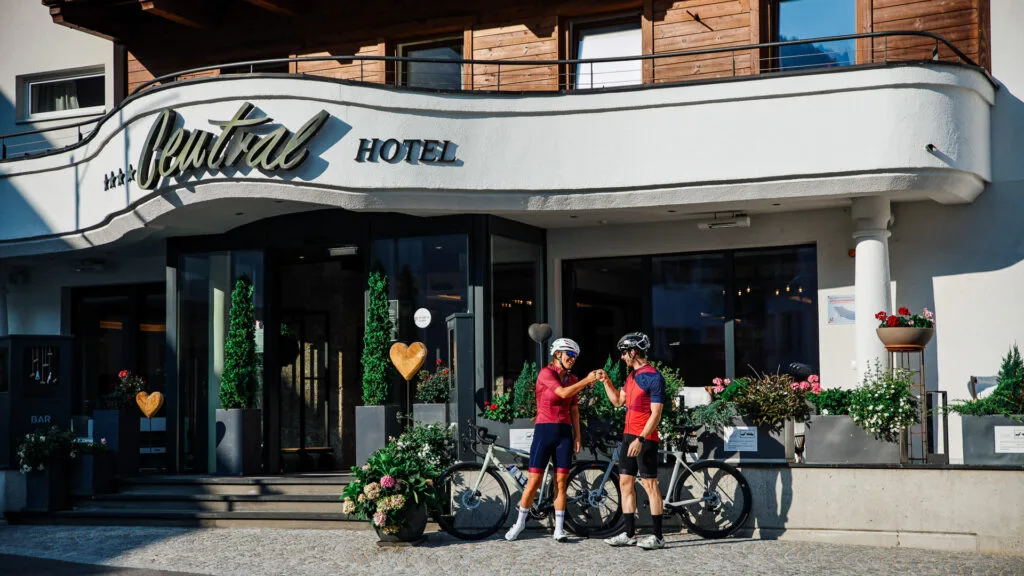 two cyclists fist bump infront of central hotel in nauders austria