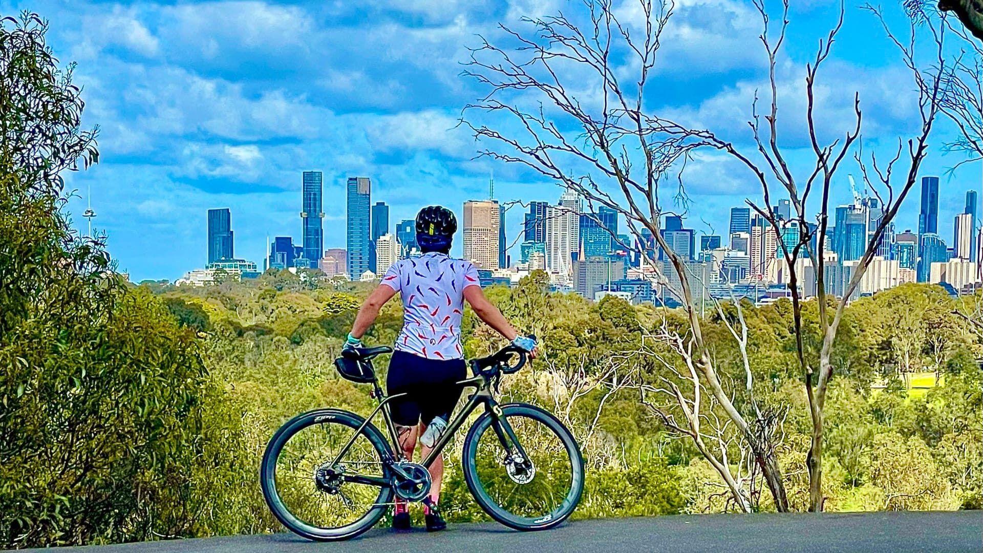 Cyclist in Melbourne admiring the city skyline
