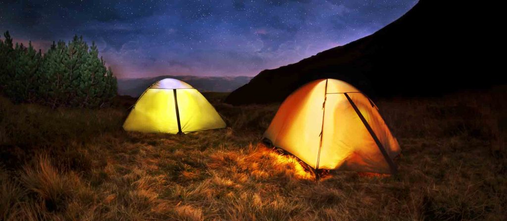 On a cheap cycling holiday with tents illuminated at night