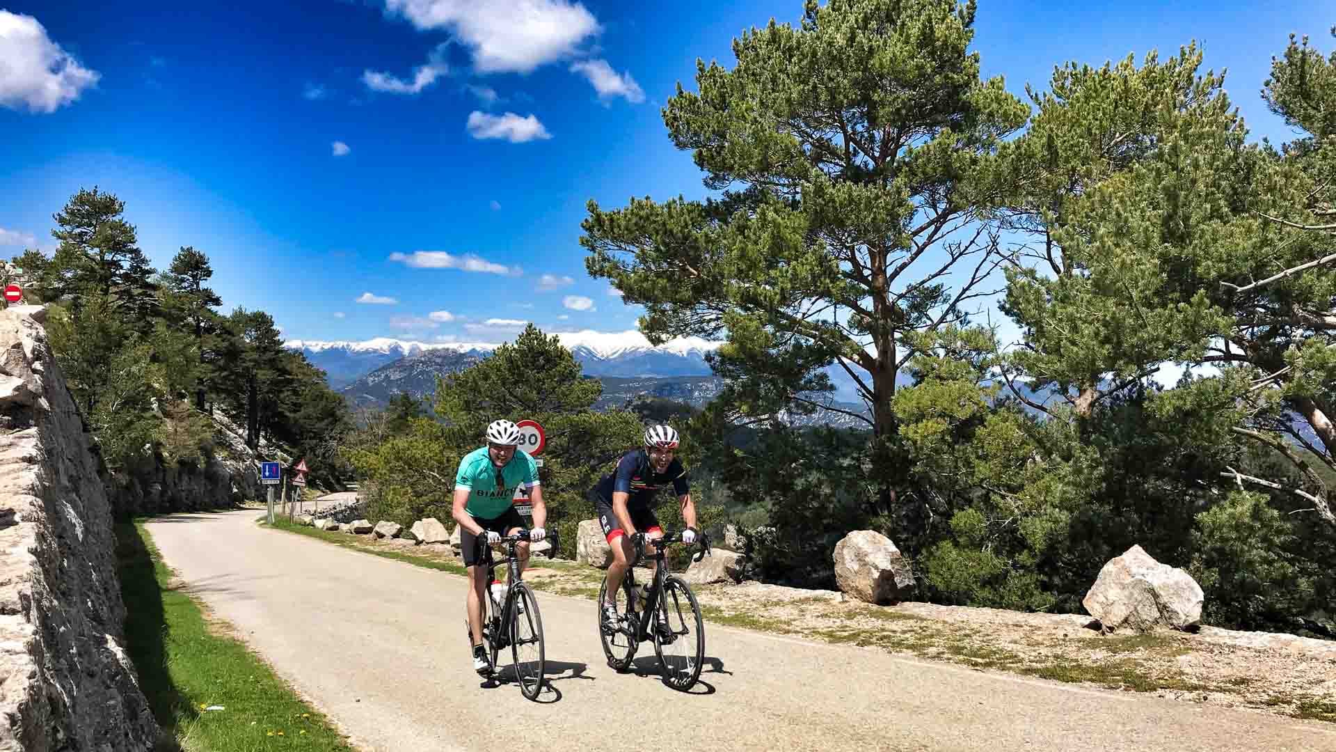 Two cyclists are training on the hill road of the cycling camps