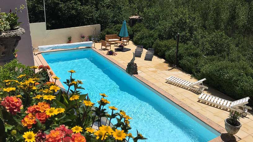 Swimming pool surrounded by flowers at cycling hotel in France