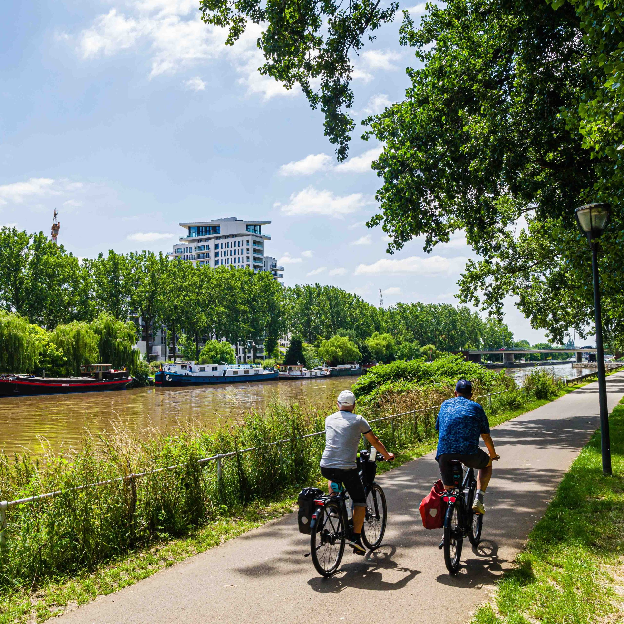 Two cyclists cycling along the river in Brussels