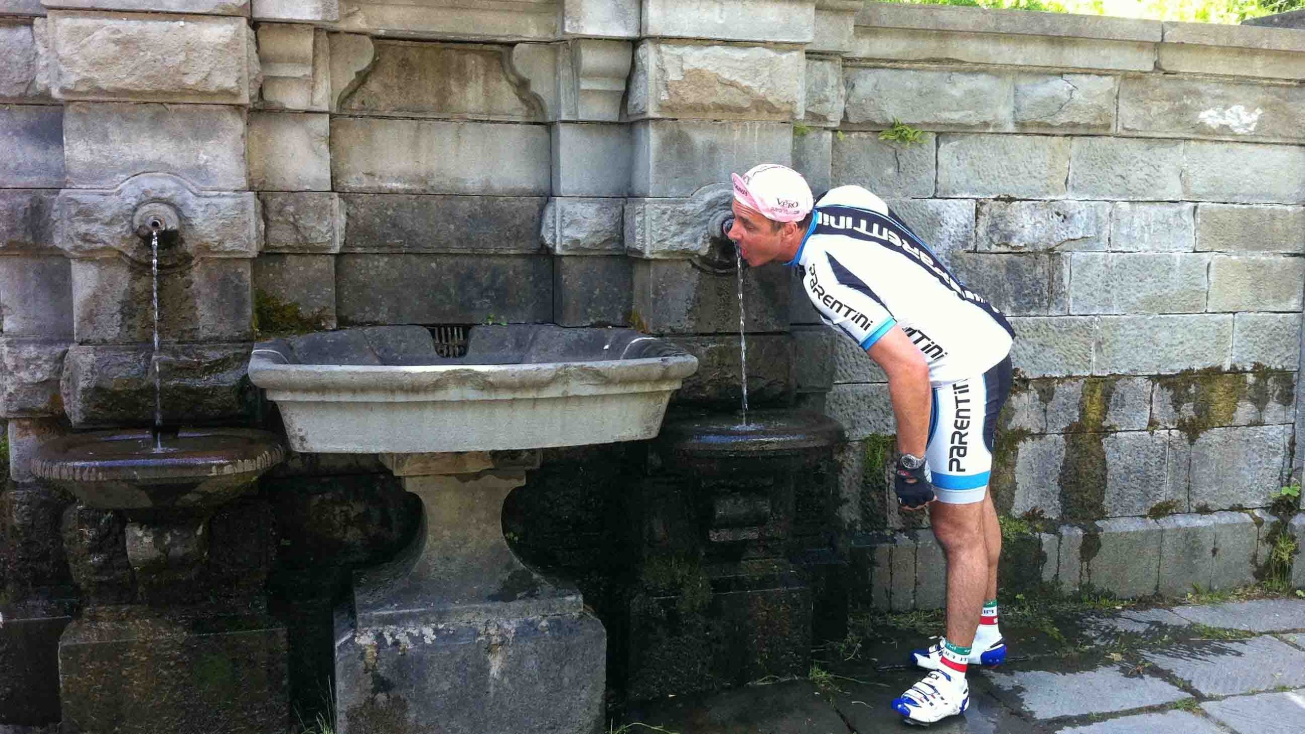 Cyclist drinking from a water fountain
