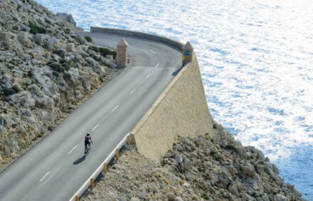 Cyclist on a long distance ride on a Mallorca cycling climb by the sea