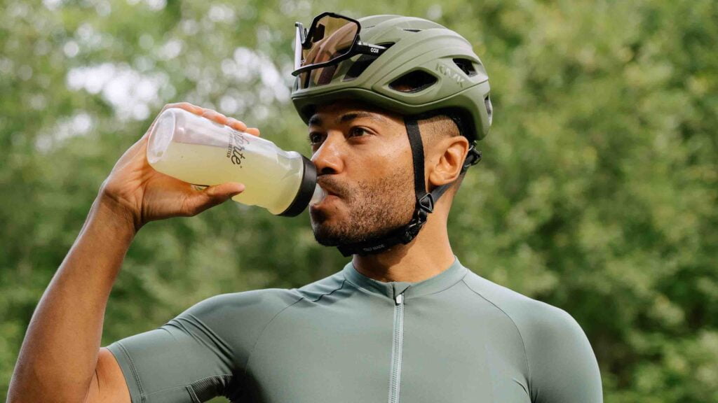 Cyclist drinking electrolyte drink on a long distance bike ride