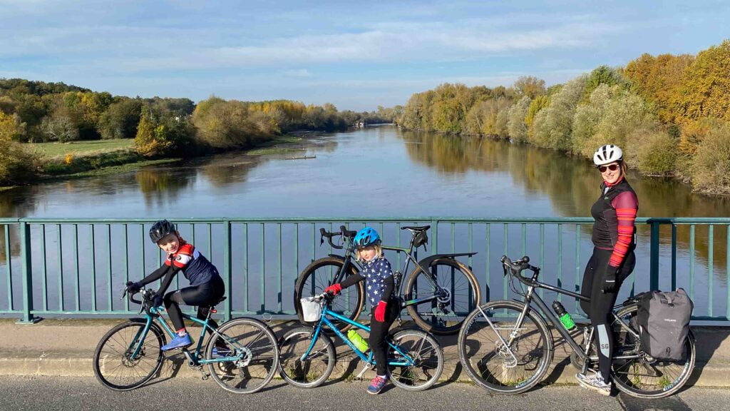 Family cycling across a river on a family cycling trip in France