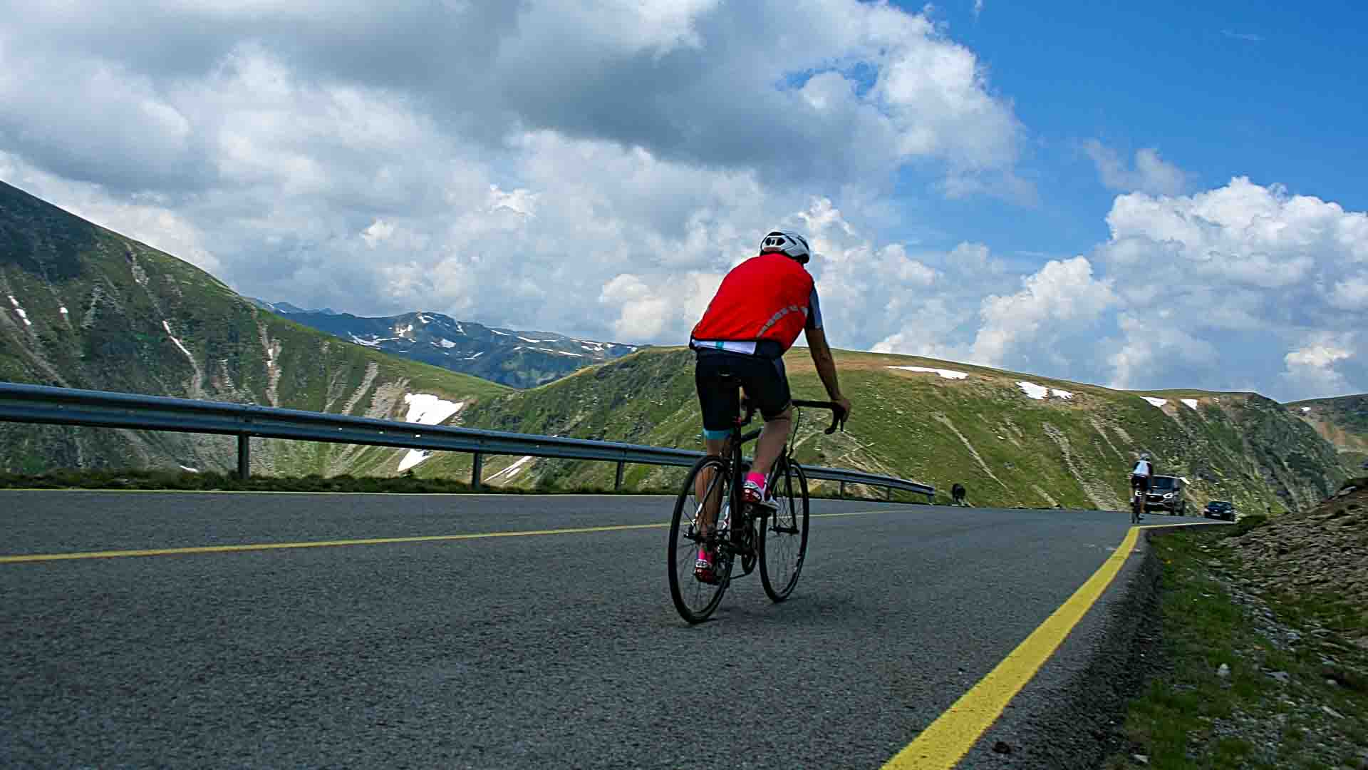 Cyclist in red jersey on Transalpina cycling route