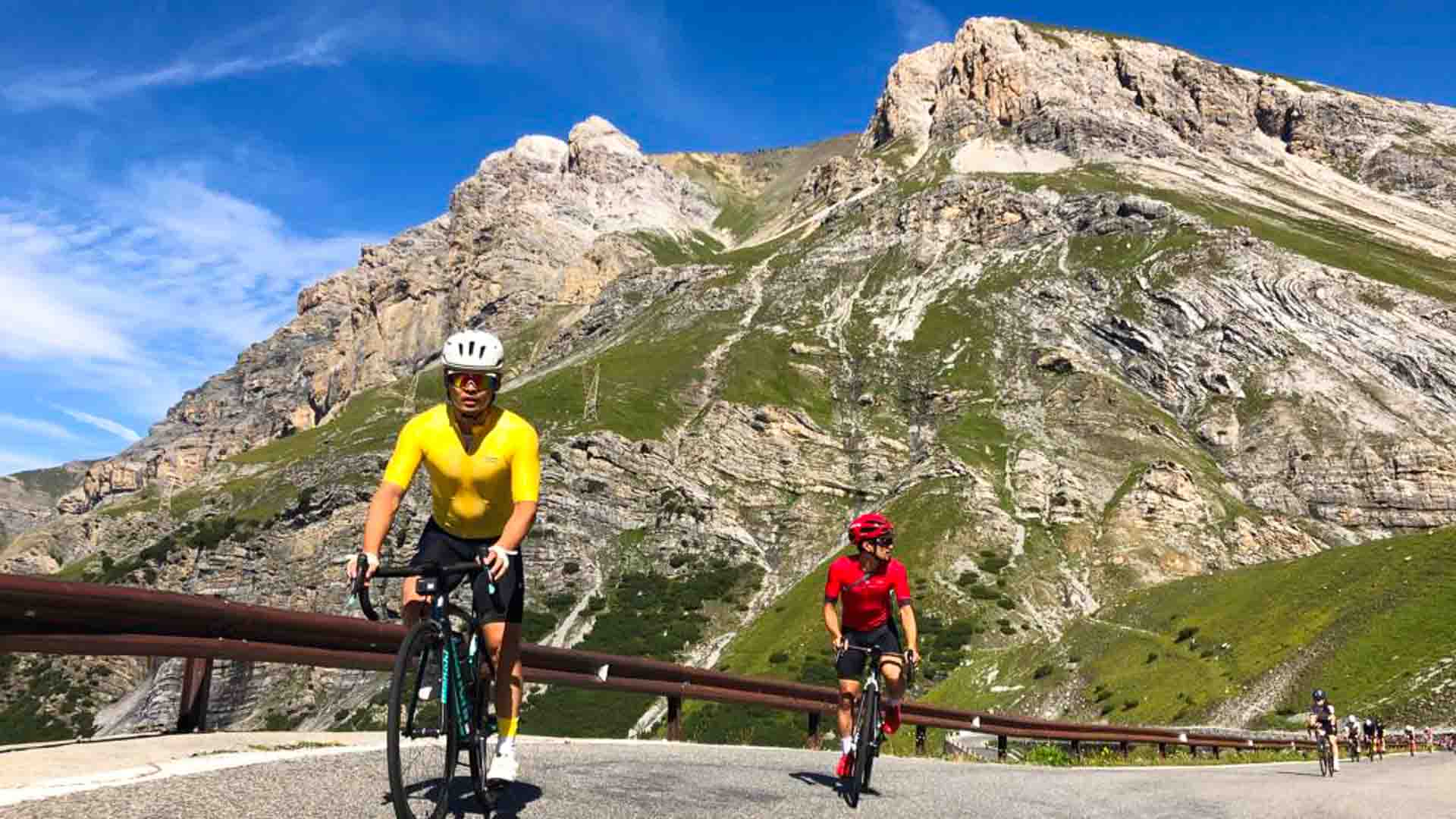 Cyclists with Dolomites mountains backdrop