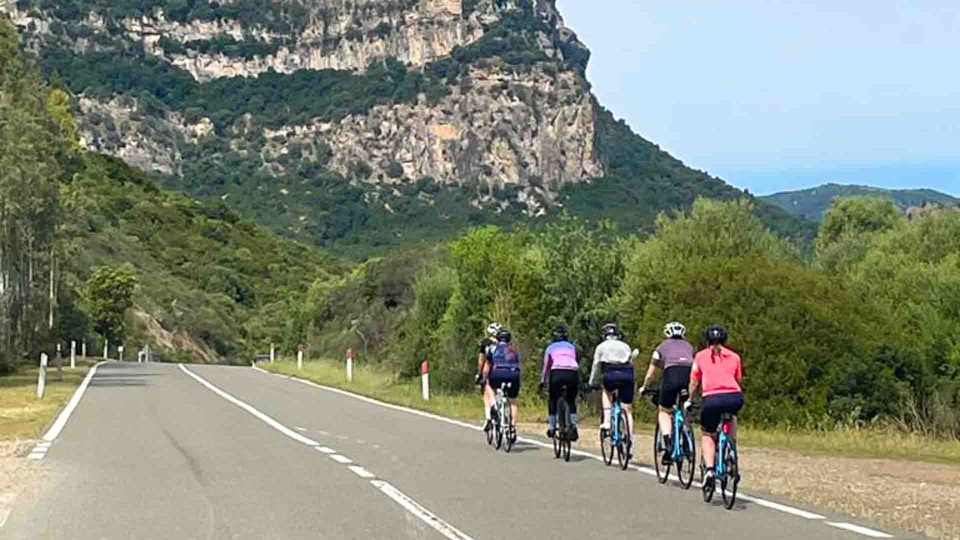 Group of women cycling with big mountain in distance