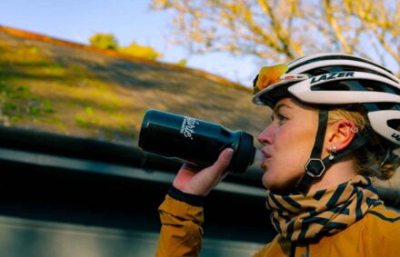 Cyclist drinking cycling hydration products form black water bottle
