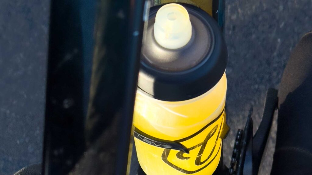 Bottle of yellow Veloforte cycling hydration drink in bottle cage on bike