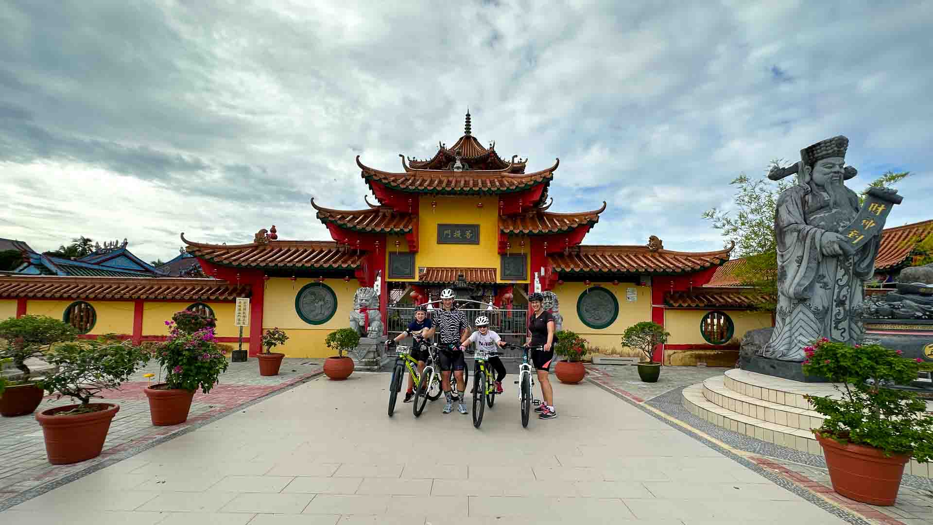 Temple in Borneo with cyclists standing outside