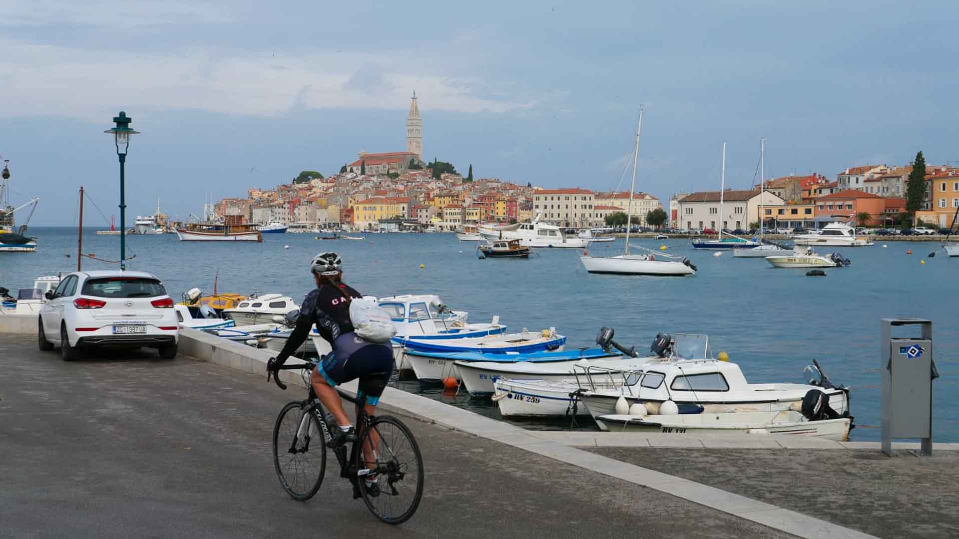 Cyclist on a pier by sea opposite Rovinj Croatia