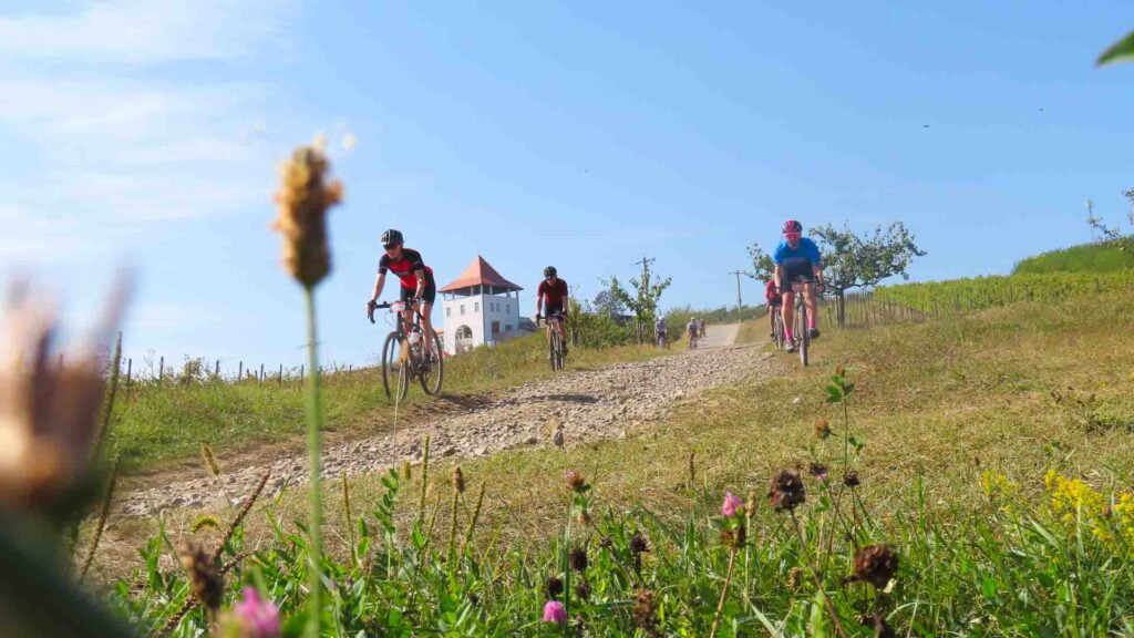 Gravel cycling through Romania on a bike tour off road with church behind