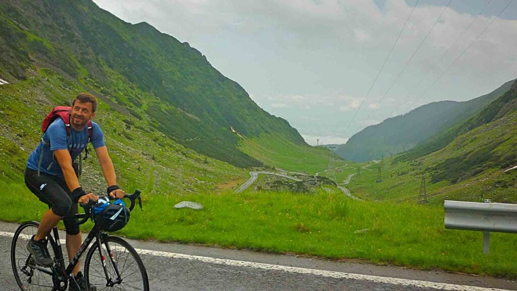 Cyclist at the top of the Transfagarasan Pass in Romania