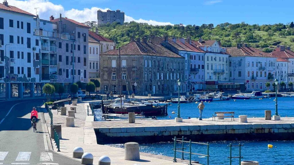 Road cycling through a pretty port town in croatia