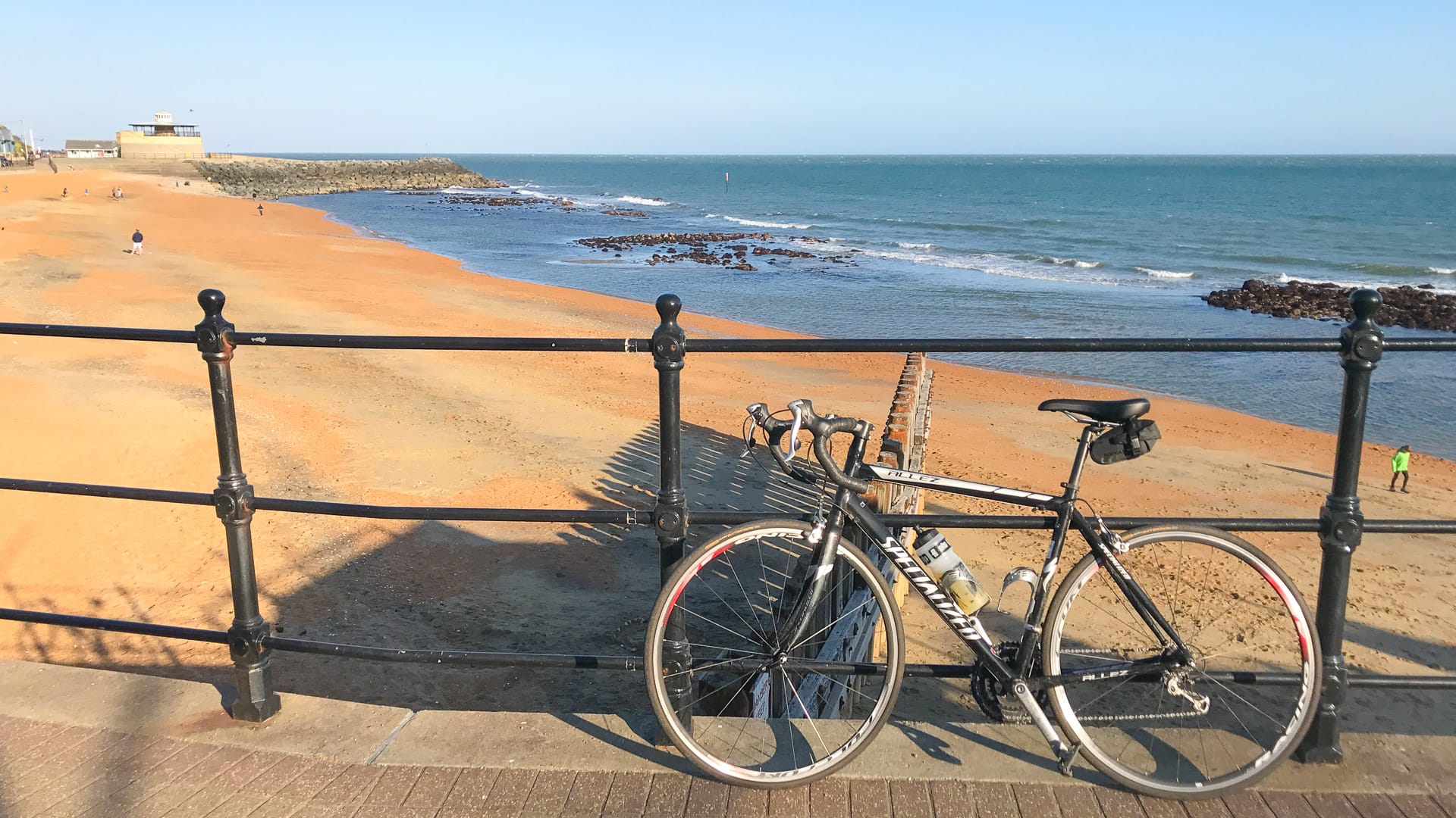 Golden sands with bicycle in front of railings at Ventnor esplanada