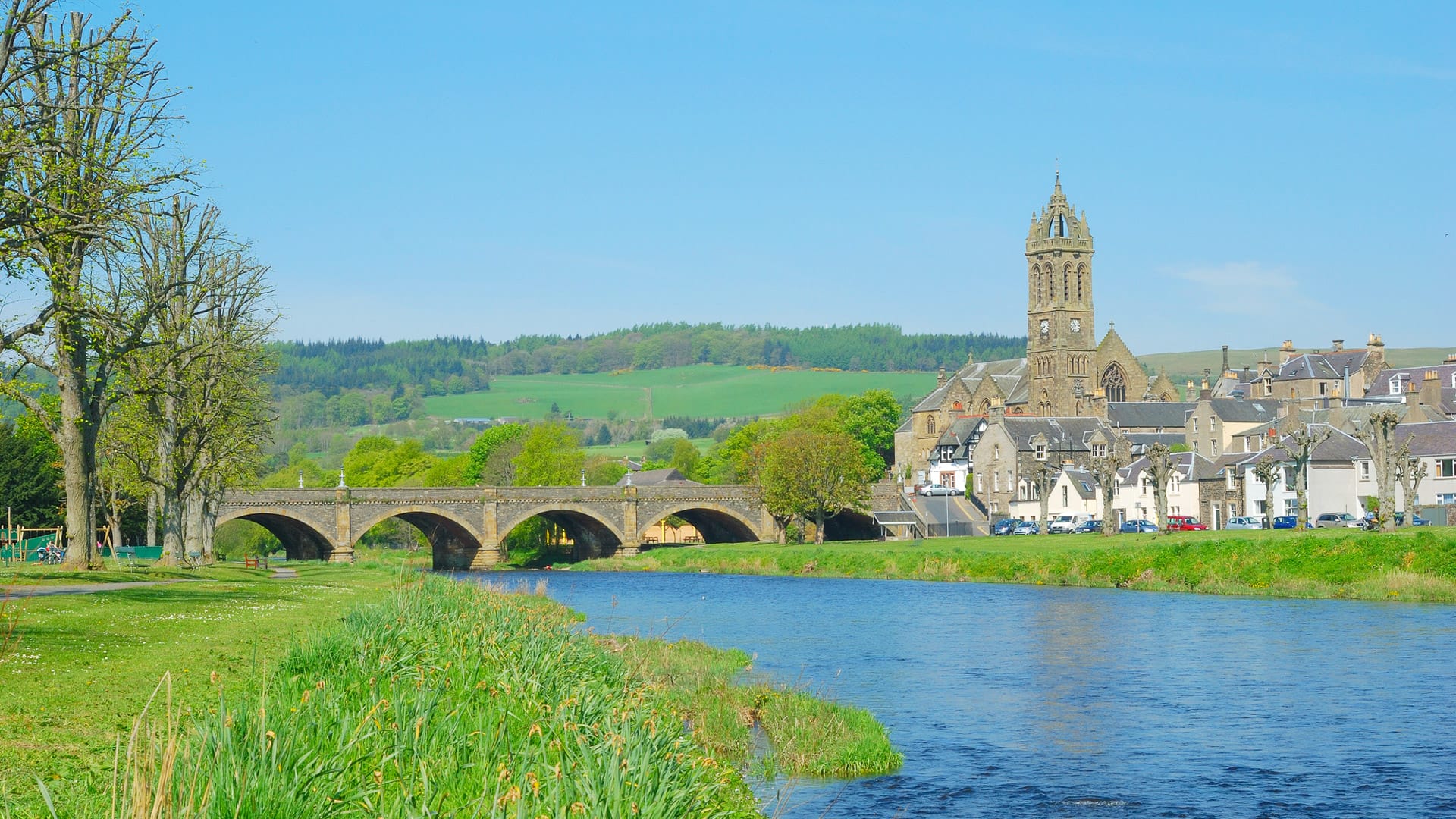 Stone traffic bridge over the River Tweed at Peebles with church tower